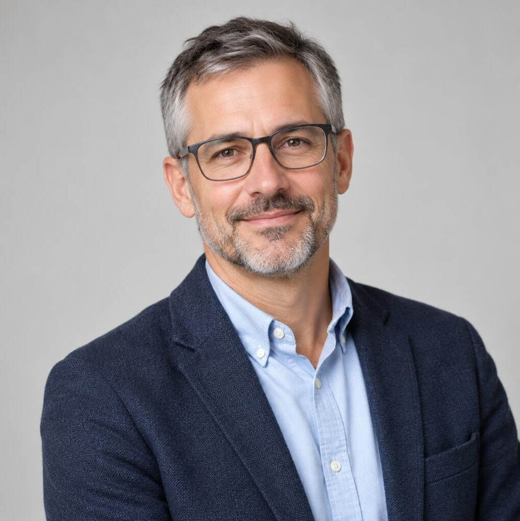 Studio portrait of a Swiss man in his forties, editor in chief, smiling confidently